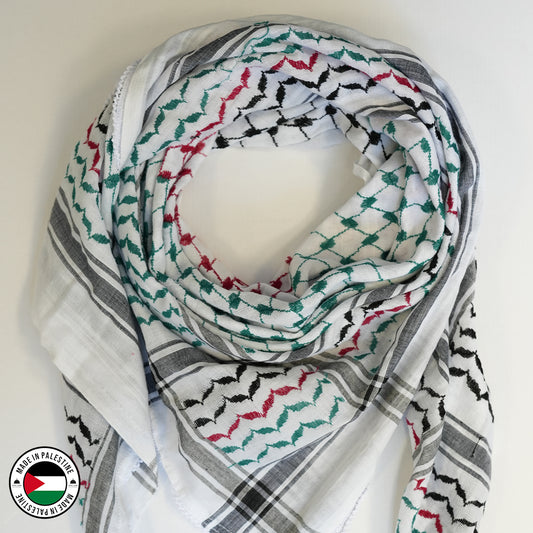 A traditional Palestine flag Hirbawi Kufiya (kuffiyeh) with a geometric pattern in red, green, black, and white colors, displayed on a flat surface.
